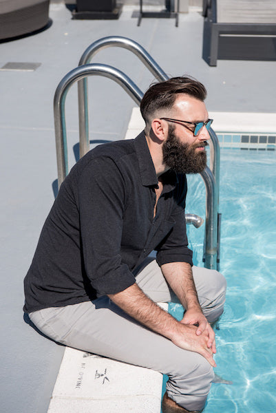 man with beard sitting by the pool. Do beards make you warmer?
