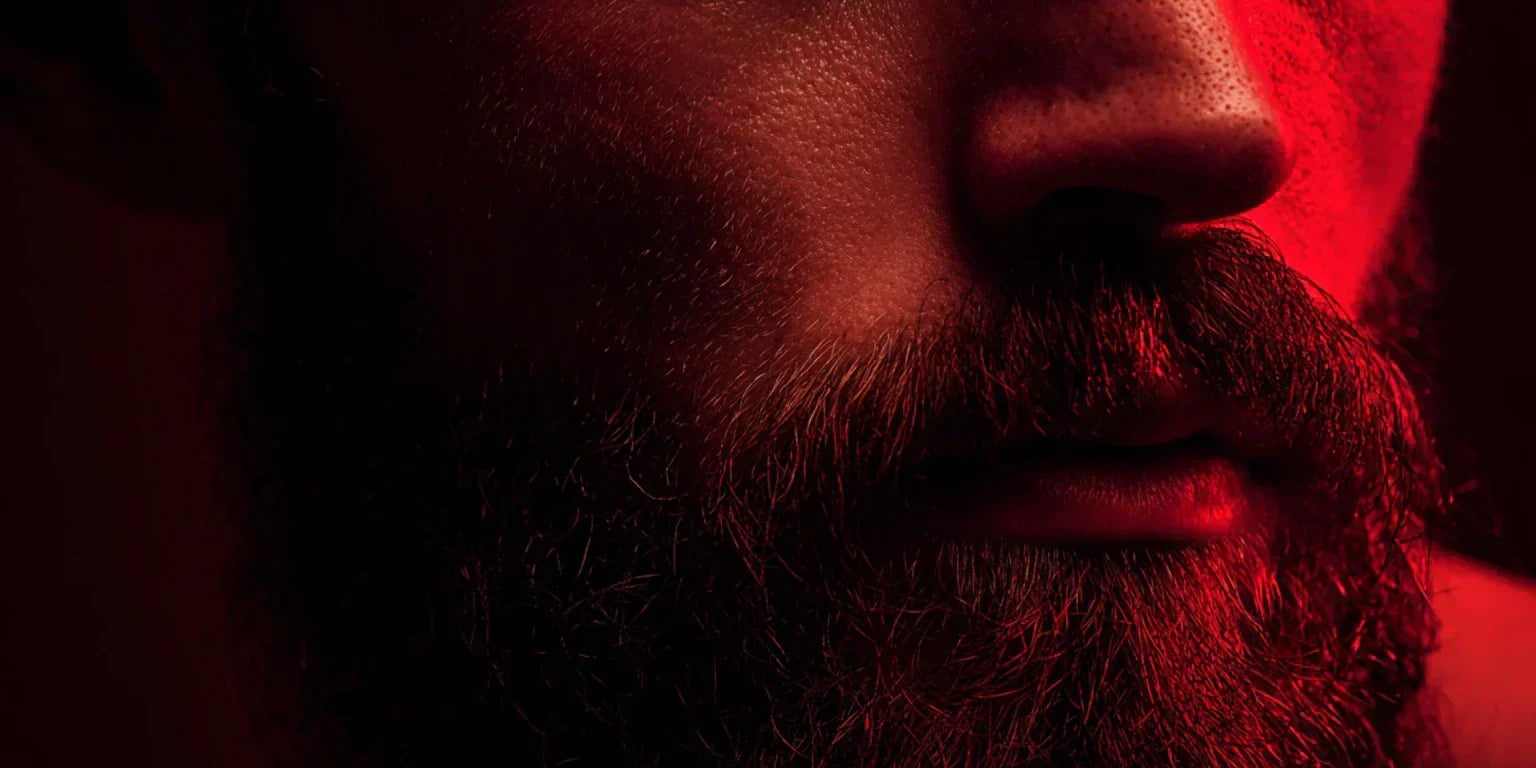 Close-up of a man's beard and jawline illuminated by red light therapy