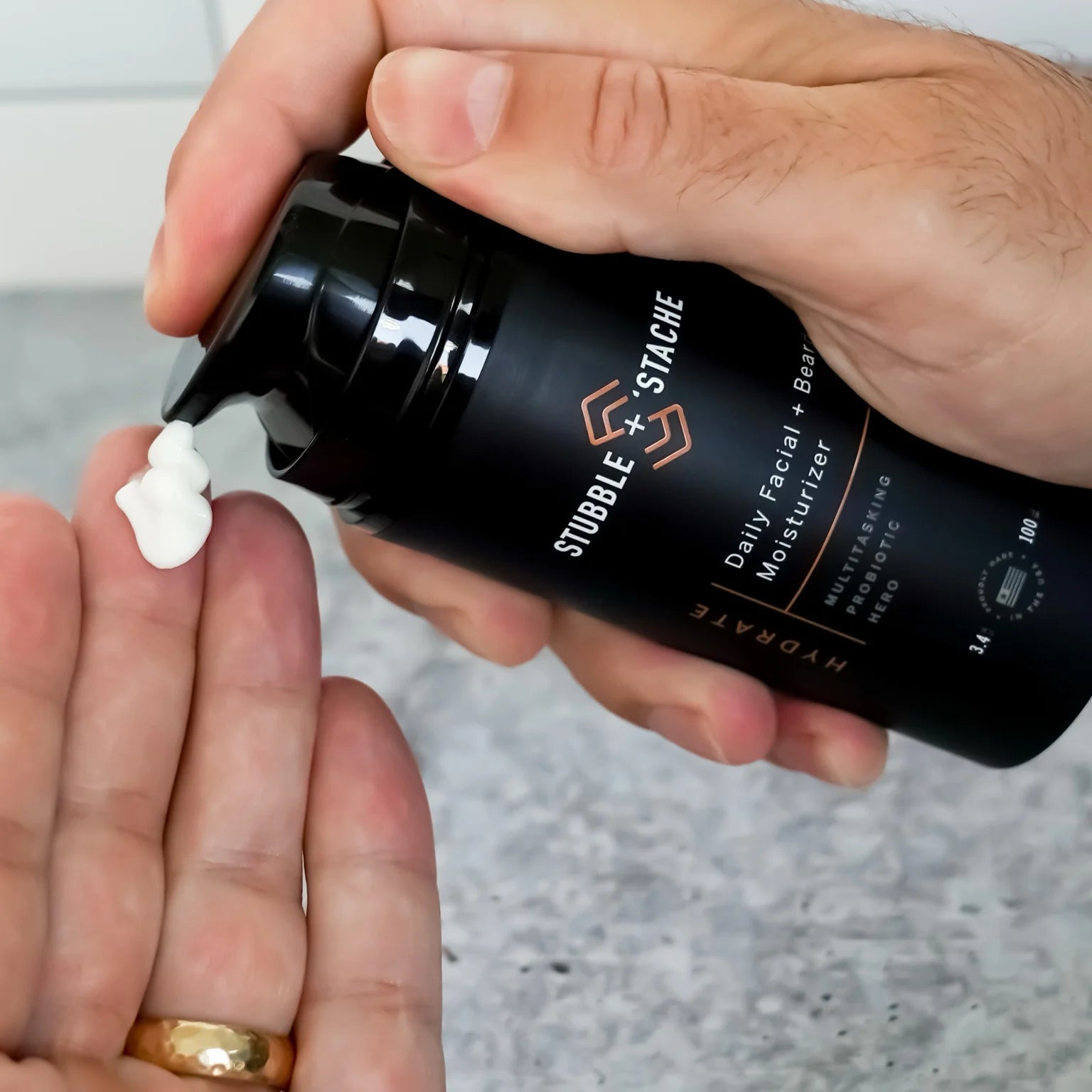 Dispensing Stubble & Stache Hydrate daily facial + beard moisturizer into hand, Step 2 of the Face + Beard Care System.