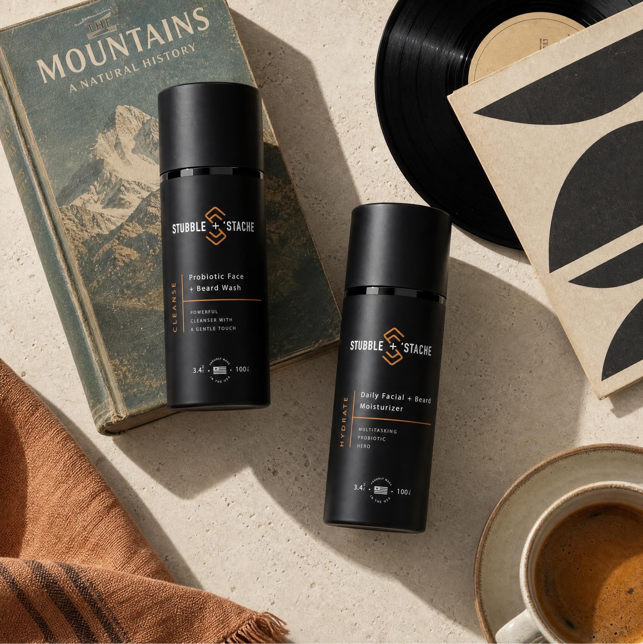 Face + Beard Essentials Kit — Cleanse and Hydrate flat lay with vintage mountain book, record, and morning coffee