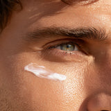 Man’s eye with Refresh Eye Cream applied under-eye area, mobile close-up view